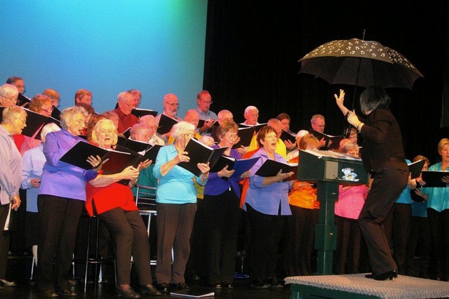 A Choir Singing while Holding Music Sheets